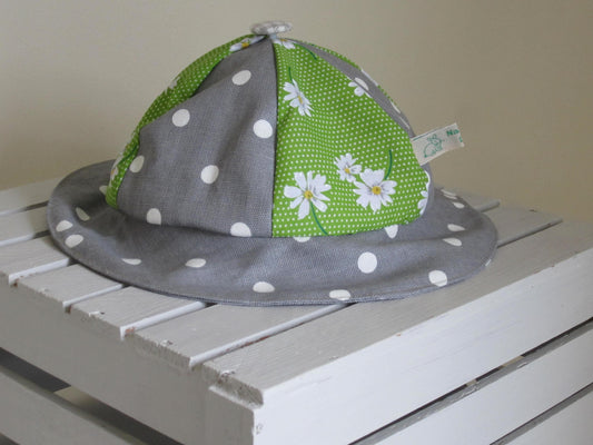 Kid's Sun Hat Made of Grey and White Polka Dot Cotton Fabric with a Daisy Patterned Insert and Pure White Lining with a Button Top Detail