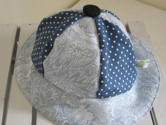 Kid's Sun Hat Made of Grey and White Floral Cotton Fabric and Navy Polka Dot Insert and Pure White Lining with a Button Top Detail