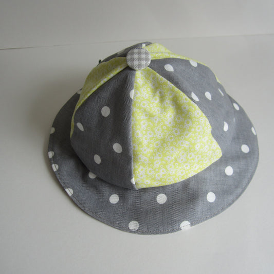 Kid's Sun Hat Made of Grey and White Polka Dot Cotton Fabric with a Yellow Floral Insert and Pure White Lining with a Button Top Detail